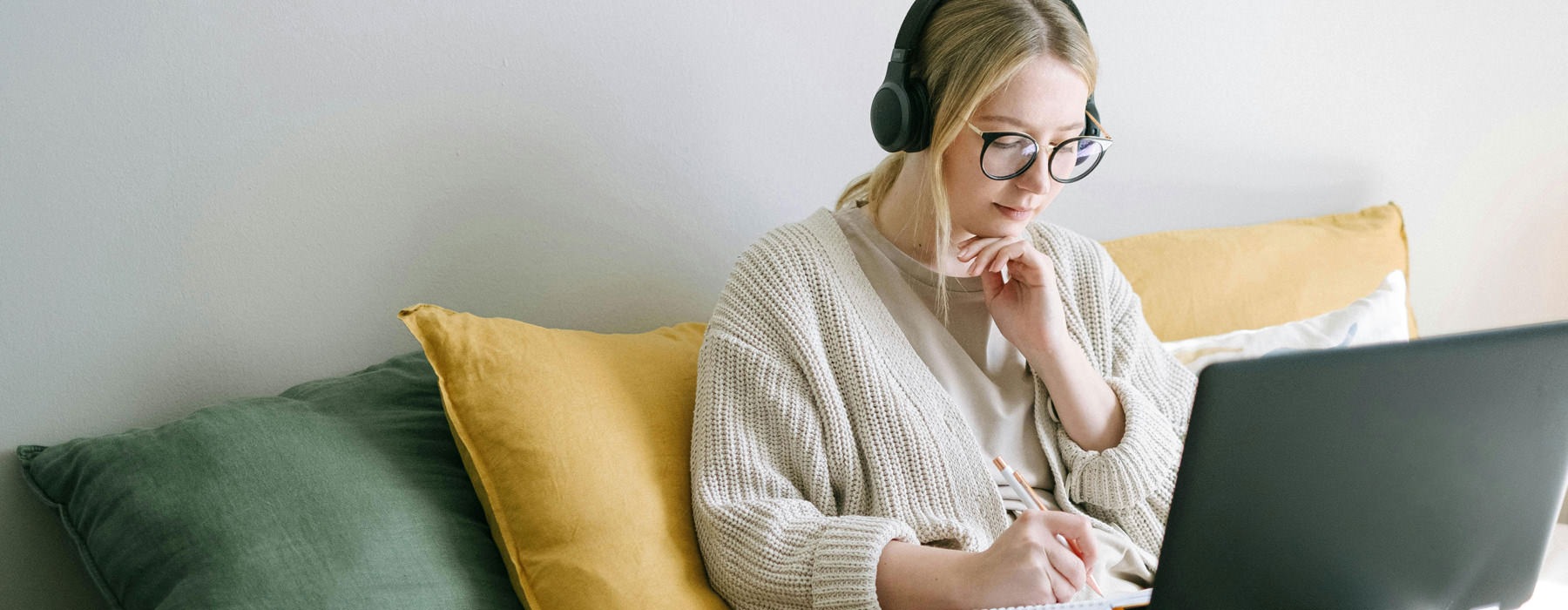 woman sits on a couch with her laptop